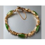 A 14CT YELLOW GOLD JADEITE BRACELET, oval jadeite interspaced with fancy links, ending in a fold-