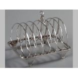A 19TH CENTURY ENGLISH SILVER TOAST RACK, MARKS INDECIPHERABLE, with applied scroll carrying handle,