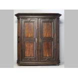AN EARLY 18TH CENTURY DUTCH OAK CUPBOARD, the swept pediment above two doors cushion panelled in