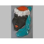 A GOLDSCHEIDER TERRACOTTA ART DECO WALL MASK, lady with blue feathered head dress, base stamped Made