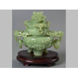 A CHINESE HARDSTONE CENSER, heavily carved with lion head handles, with large pendant rings, the
