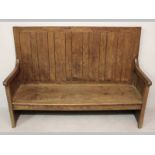 AN EARLY 10TH CENTURY ENGLISH OAK AND ELM SETTLE, the wainscoted back above block arms, a solid