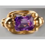 A 14CT YELLOW GOLD AMETHYST RING, rectangular shaped flanked by twin ball-shape, resting on a