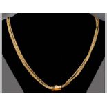 AN 18CT YELLOW GOLD CHAIN, triple strand with barrel form spacer, barrel decorated with enamel and