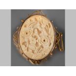 A 9CT YELLOW GOLD CARVED IVORY BROOCH, oval form floral design in a scroll gold frame, 5cm long, 4cm
