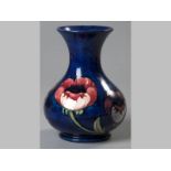 A MOORCRAFT VASE, decorated with pink poppies on a blue ground, with impressed mark, 20cm high.