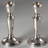 A PAIR OF .925 STD SILVER CANDLESTICKS, reeded rims, on circular base, 12cm high, filled, (2).