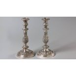 A PAIR OF SILVERPLATE CANDLESTICKS, the entire piece profusely embossed with scrolls, swags and