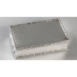 AN EDWARDIAN SILVER CIGARETTE BOX, LONDON 1910. F.B., of rectangular form, the rims embossed with