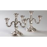A PAIR OF .830 STD CONTINENTAL SILVER CANDELABRA, with scrolled arms, tapered stems on circular