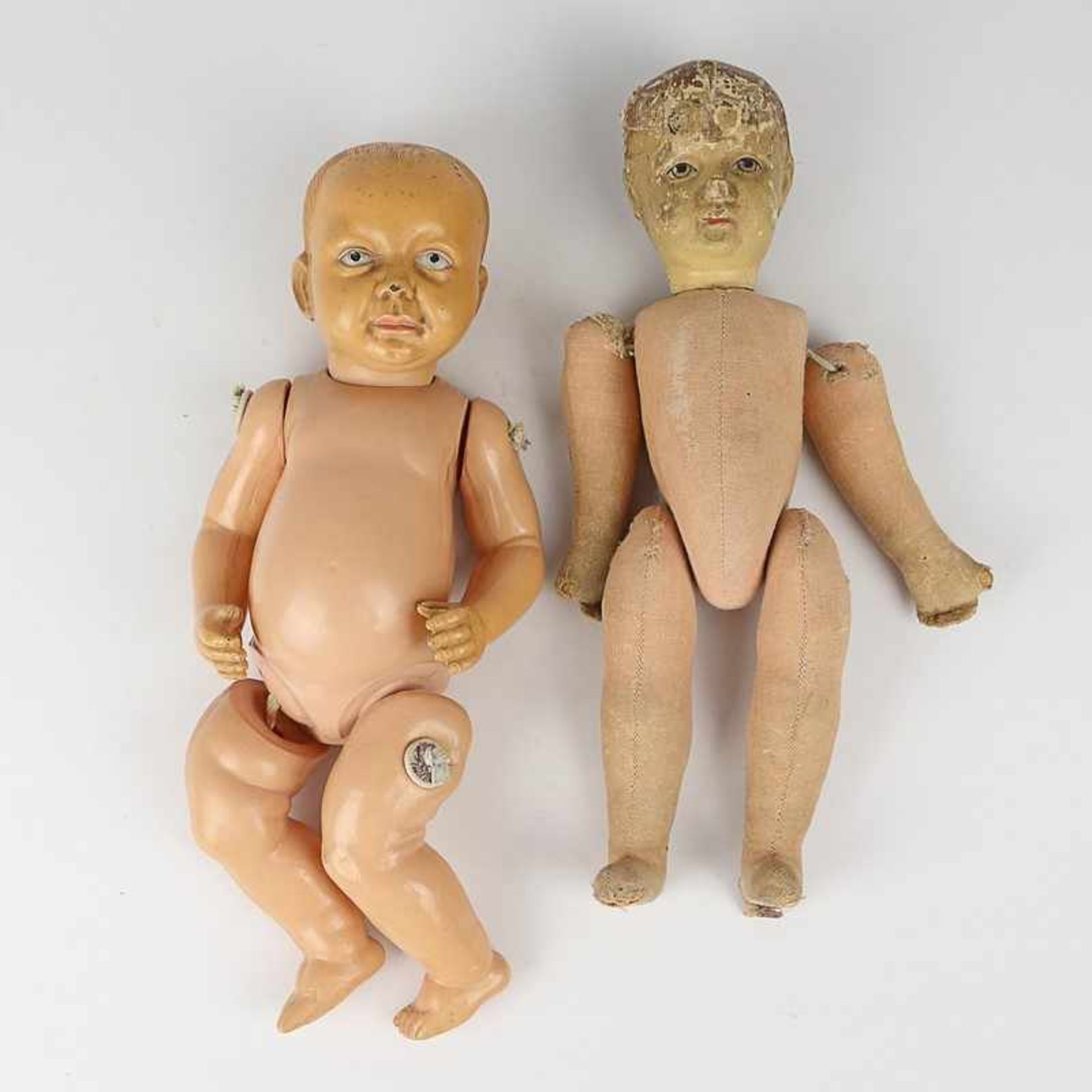 Puppen 2 T.; 1x Baby, Charakterkopf aus Celluloid, Kunststoffkörper; 1x Junge, Stoffkörper,