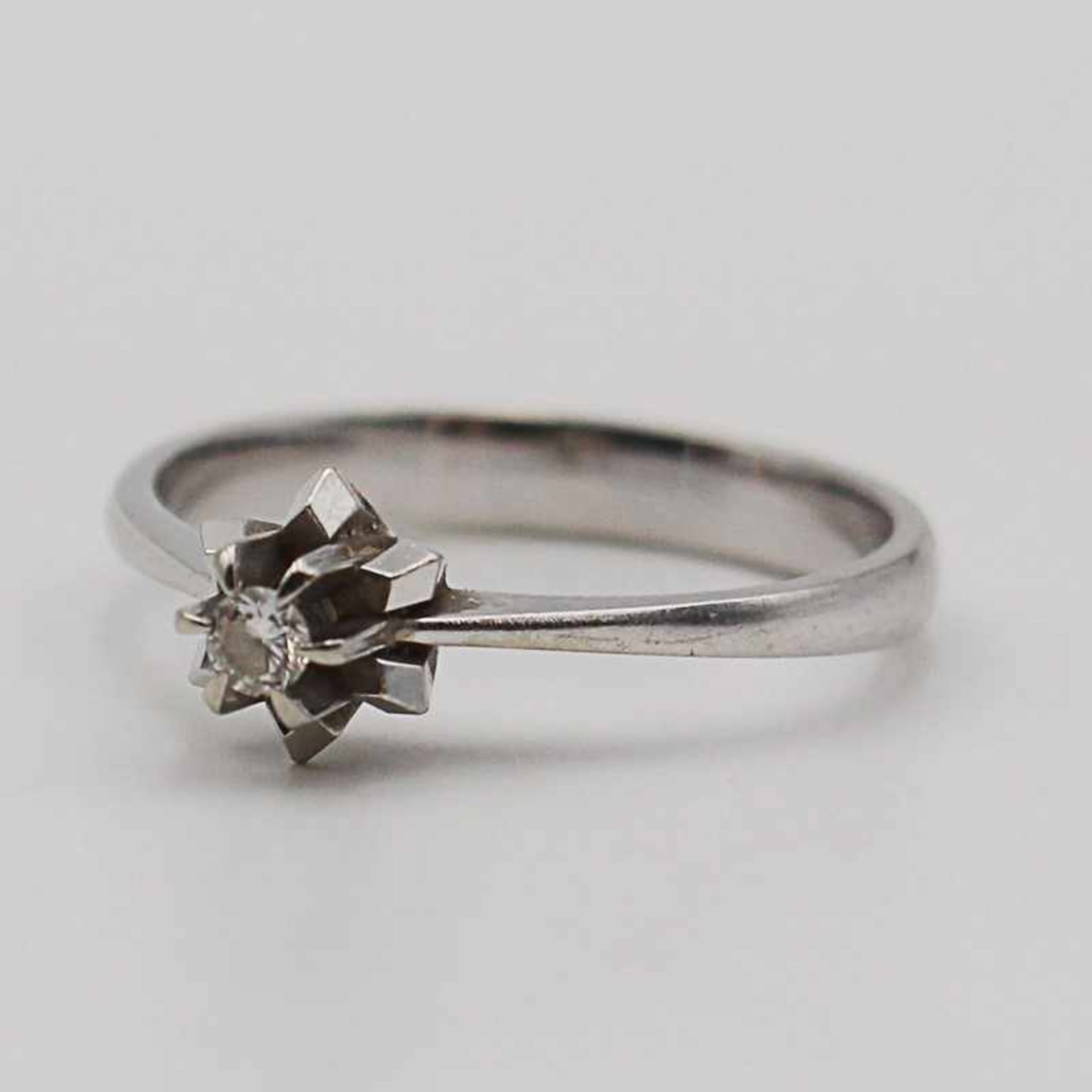 Diamant - DamenringWG 750, sternförmig gestufter Ringkopf, mittig besetzt mit einem Diamant, ca.0,
