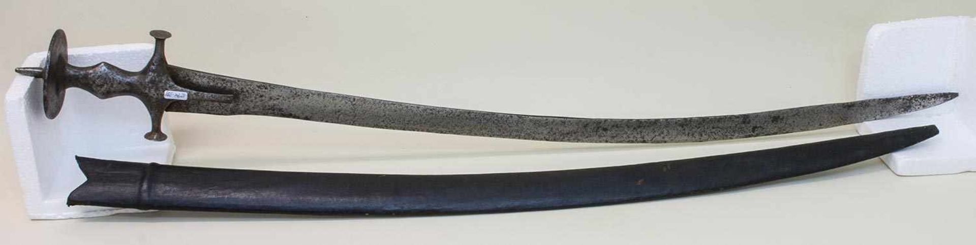 Tulwar Indien um 19. Jh., geschmiedetes Eisengefäß, gekrümmte Rückenklinge, Lederscheide, L. 91 cm