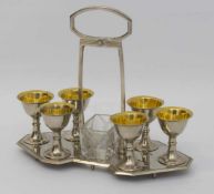 Eierbecher-Set um 1910, Metall, 6 Eierbecher auf Tablett (auf Stifte gesteckt), dazu Pressglas