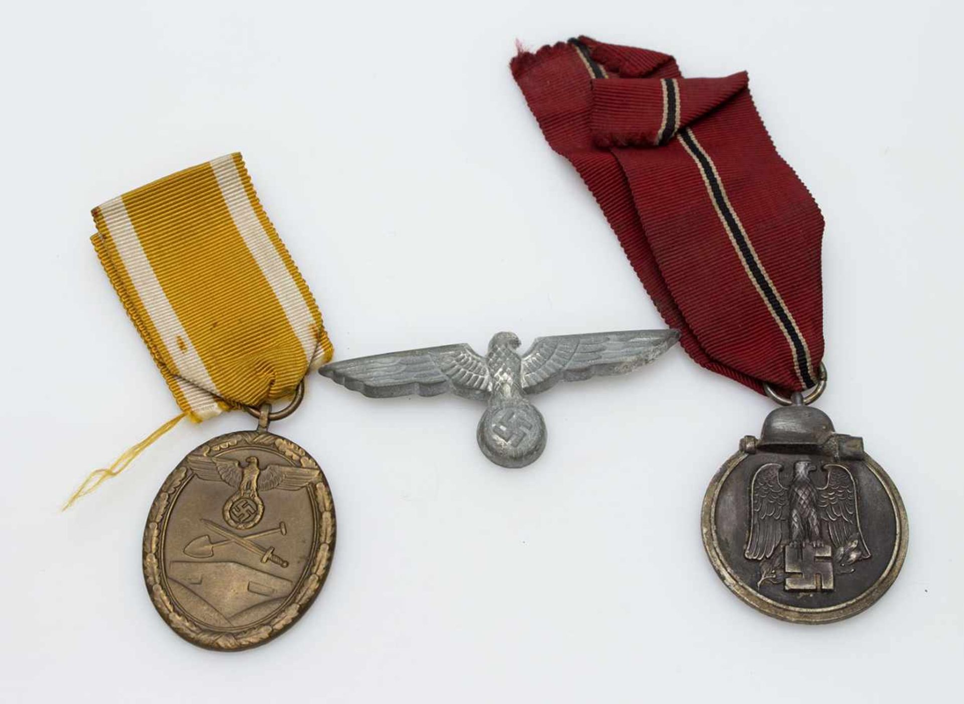Lot III. Reich, Mützenadler, Ostmedaille u. Deutsches Schutzwall-Ehrenzeichen, beide am Band