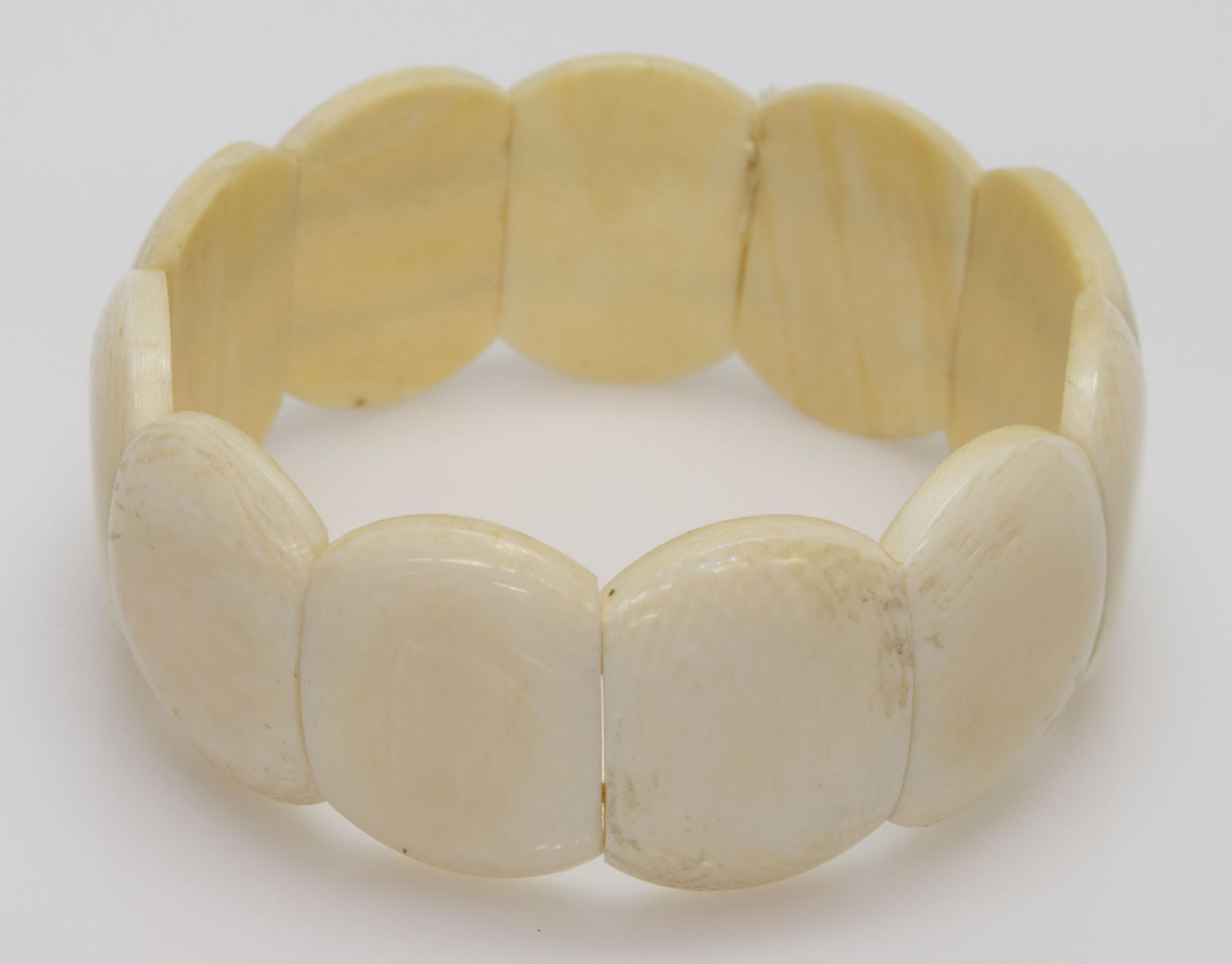 Armbandflache Elfenbeinstücke, auf Gummi aufgezogen, 2,5 x 1,8 cm, D. 6 cm