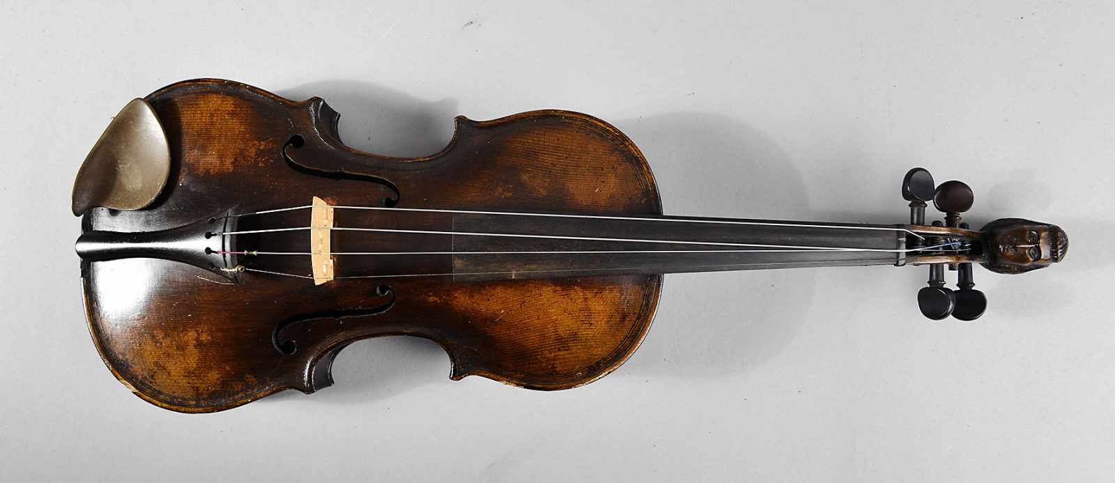 Violine Anfang 20. Jh., dunkelbraun gebeizt, Boden mit geschnitztem Burgmotiv, geschnitzter Kopf