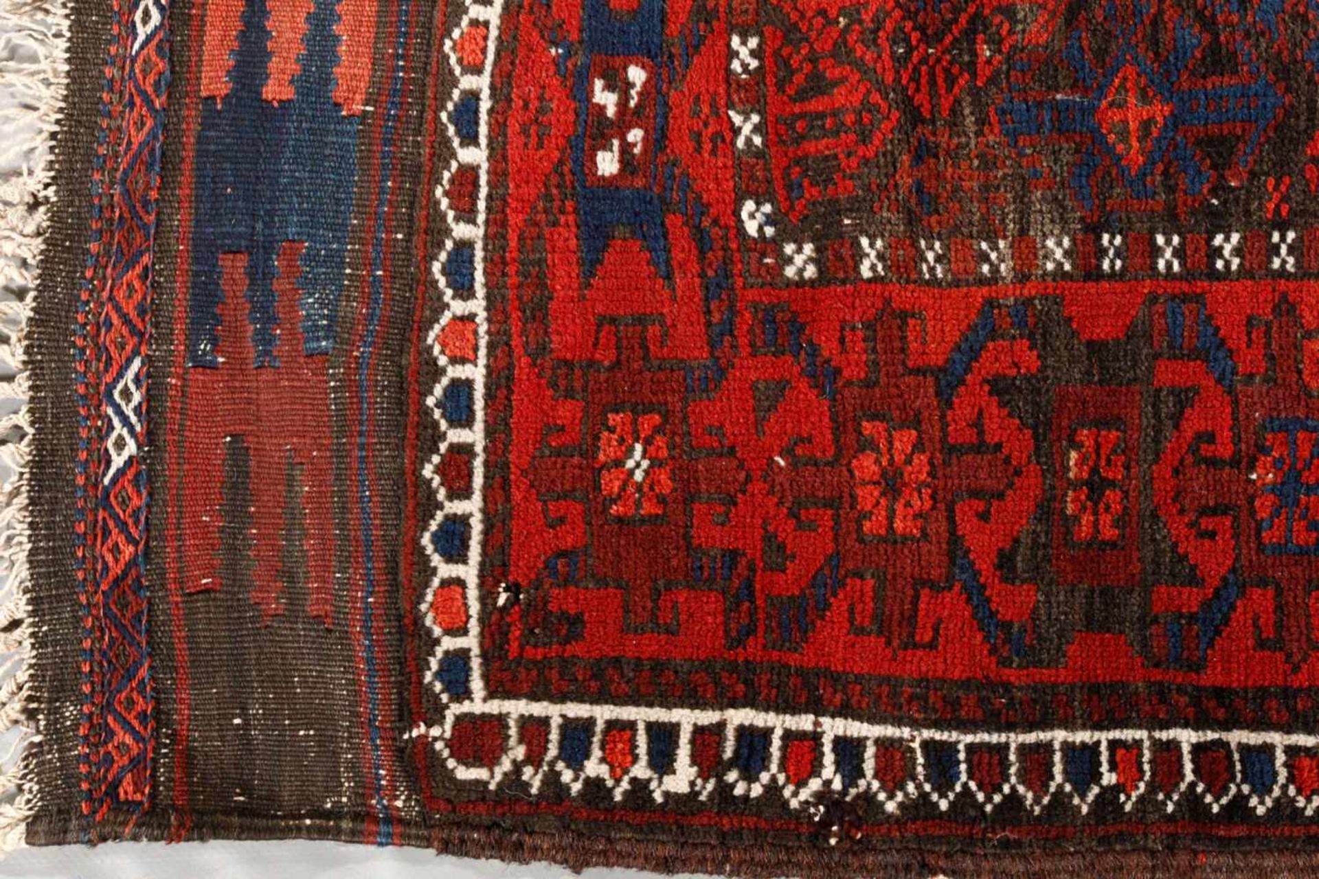 Belutsch Teppich um 1900, rapportierter geometrischer Dekor auf rotem Fond im kräftigen Kolorit, gut - Bild 2 aus 3
