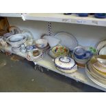 Two shelves of 19th century and later dinner wares including meat plates, tureens and covers,