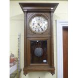 An early 20th century German wall clock in oak case, and an Edwardian mahogany small hanging cabinet