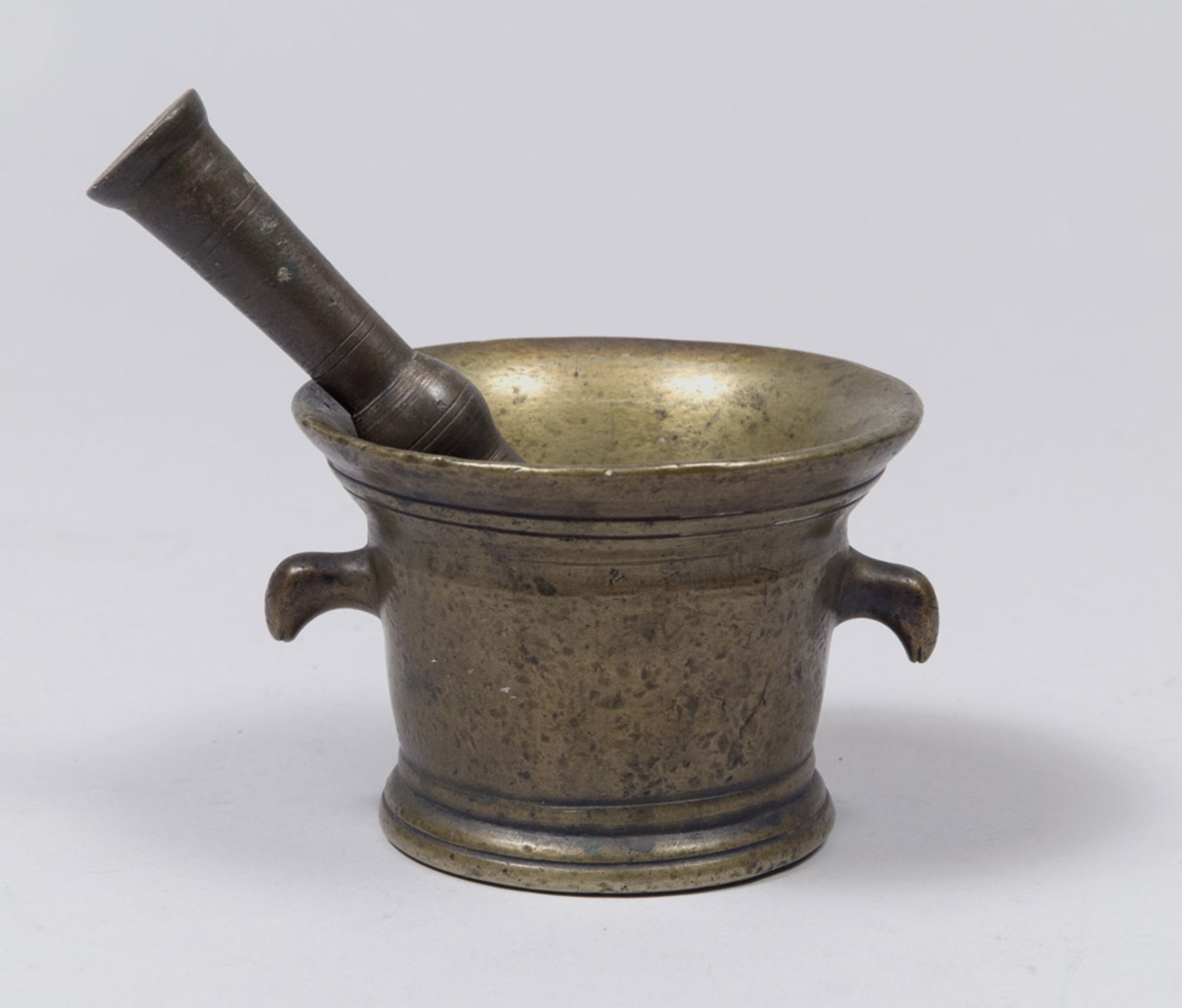 GILDED BRONZE MORTAR AND PESTLE, 17TH CENTURY with heads handles zoomorfe. Measures mortar cm. 10