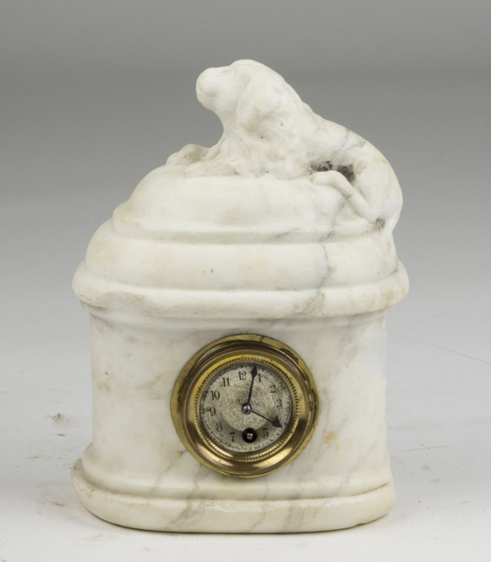 SMALL CLOCK IN WHITE MARBLE, 19TH CENTURY with figure of dog on the hat and quadrant in brass.