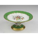 PORCELAIN CAKESTAND, 19TH CENTURY of white and green enamel decorated with colored flowers. Measures