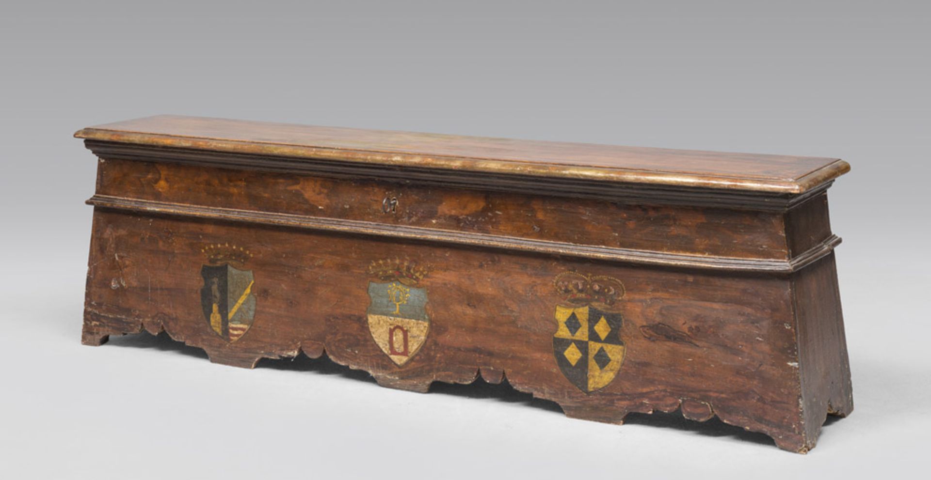 SOFTWOOD NOBLE BENCH, 18TH CENTURY brown lacquered, front painted with three coats of arms.