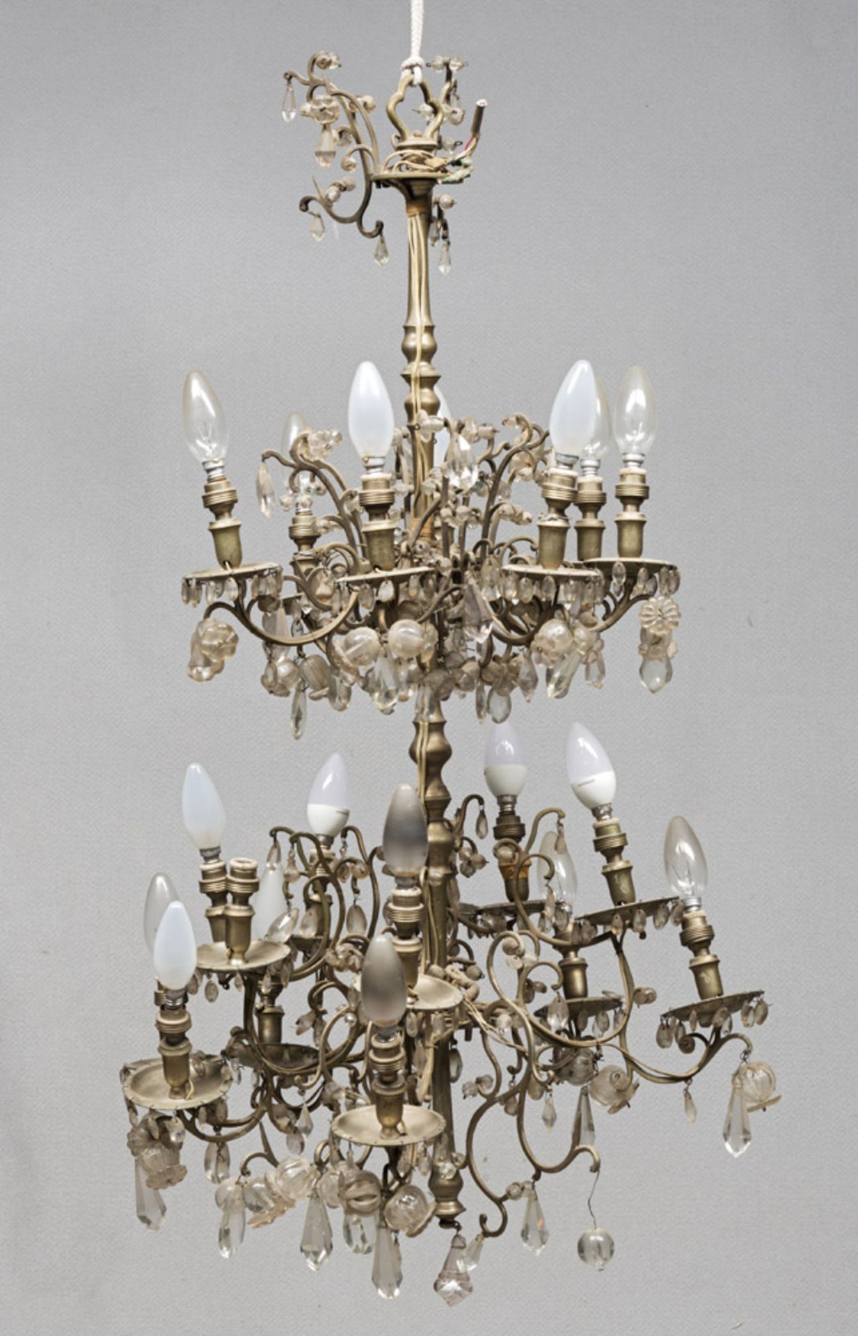 BRASS CHANDELIER, EARLY 20TH CENTURY double order of eight and twelve arms. Rich drop pendants in