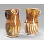 TWO PITCHERS IN EARTHENWARE, PROBABLY CALABRIA, END 19th CENTURY in brown and white enamel. Measures