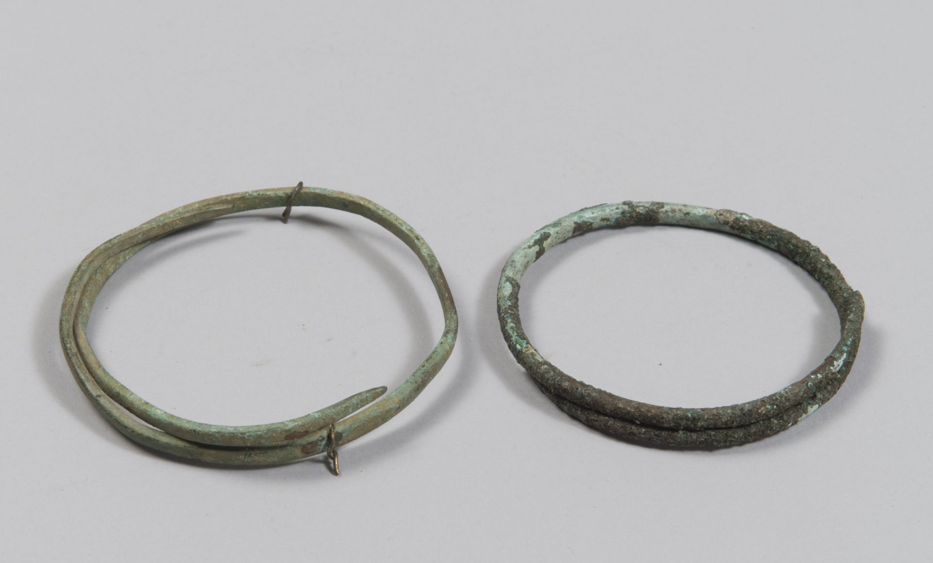 TWO ETRUSCAN BRONZE ARMILLS, 8TH-6TH CENTURY B.C. a smooth rod with a circular section and the other