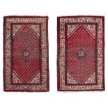 A PAIR OF HAMADAN BED RUGS, EARLY 20TH CENTURY with boteh design n the center field on red ground.