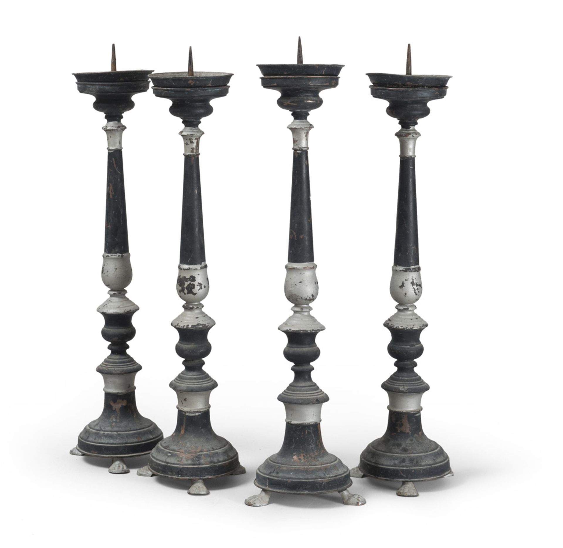 FOUR METAL CANDLESTICKS, SOUTHERN ITALY 19TH CENTURY black lacquered, claw feet. h. cm. 66. Defects.