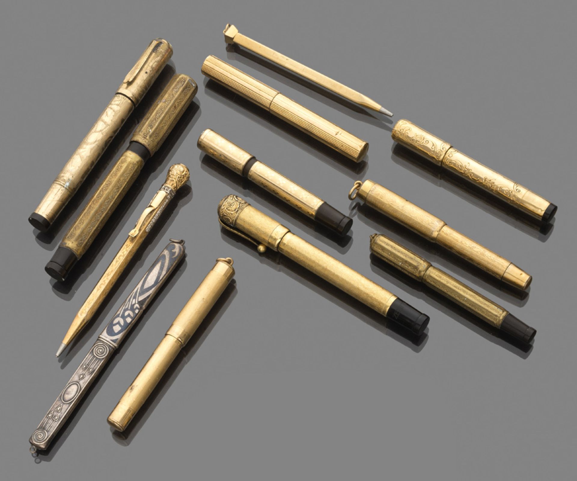 NINE FOUNTAIN PENS AND TWO PENCILS, EARLY 20TH CENTURY laminated in yellow gold, one of the