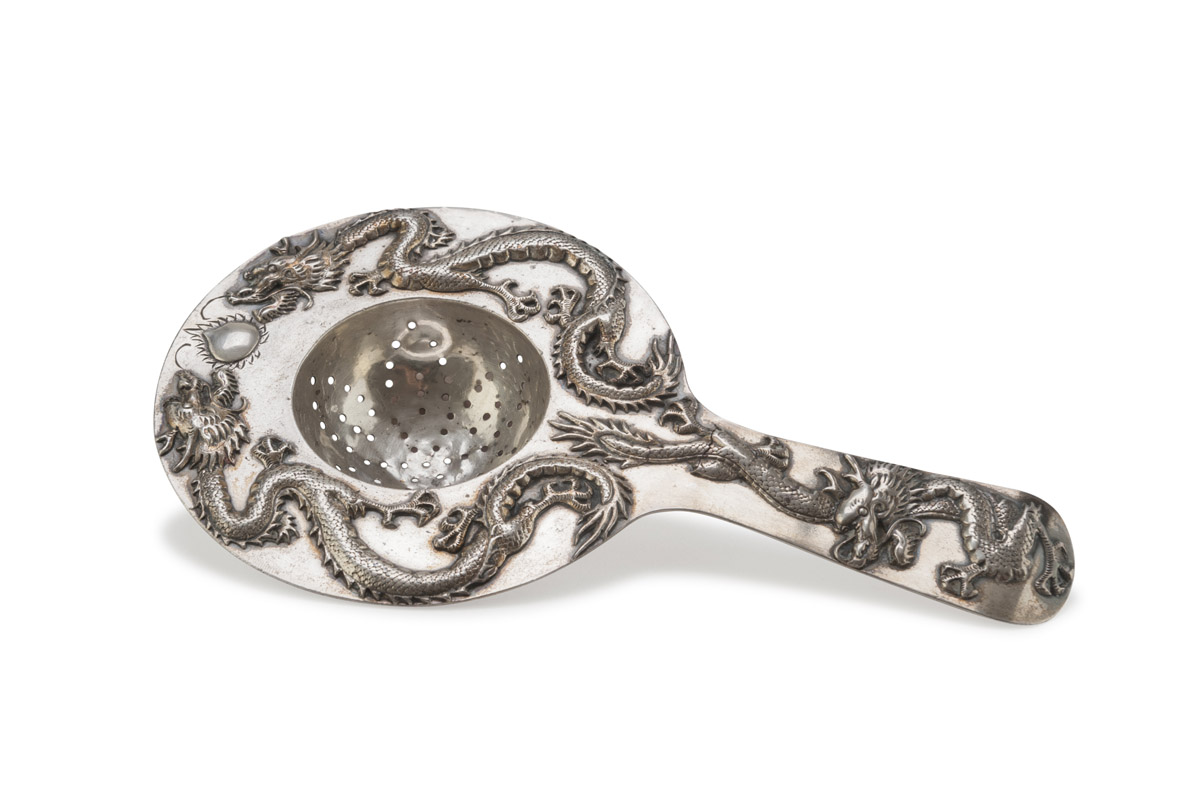 A SILVER STRAINER. PROBABLY CHINA, 19TH CENTURY. chiselled into dragons and sacred jewel. Measures