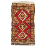 ANATOLIAN PARMAKLI CARPET, EARLY 20TH CENTURY triple jagged medallion on red field. Measures cm.