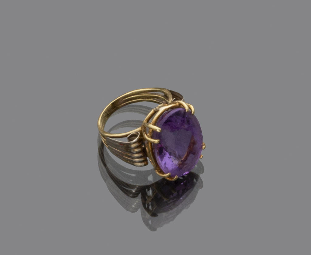 RING in gold 18 kts. with central amethyst and side decoration with spiral scrolls. Total weight gr.