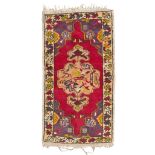 ANATOLIAN MELAS CARPET, EARLY 20TH CENTURY medallion with simbologies, in the field on red ground.