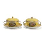 TWO SOUP CUPS, EARLY 20TH CENTURY with saucers and covers in yellow enamel decorated with flowers.