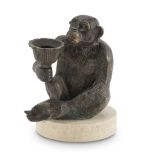 BRONZE CANDLESTICK, EARLY 20TH CENTURY with burnished patina, shaped to figure of seated Baboon,