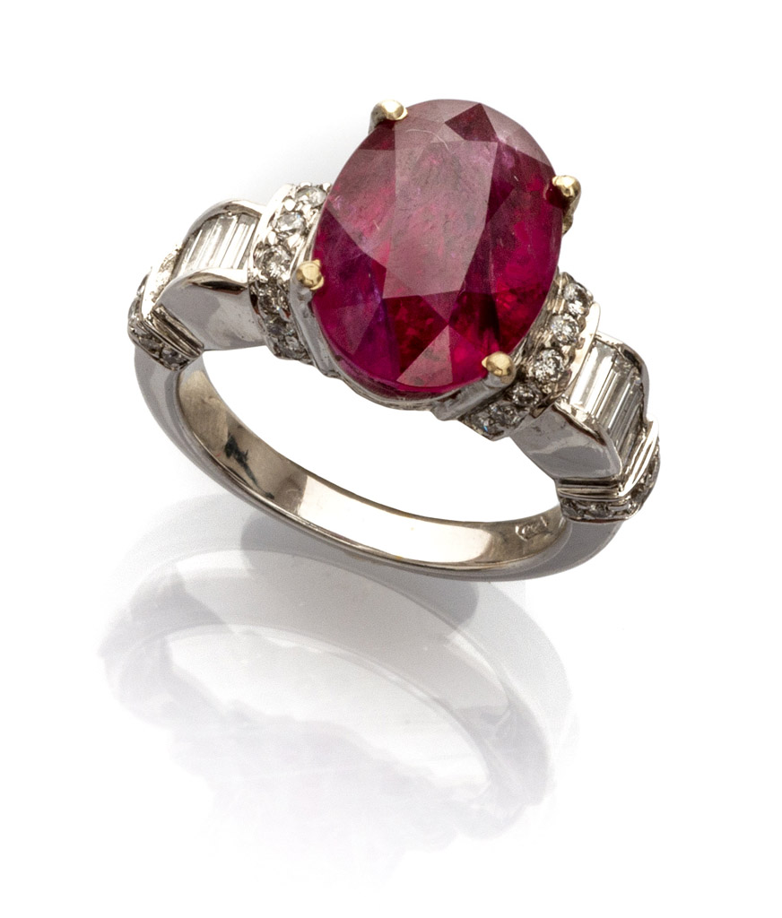 BEAUTIFUL RING in white gold 18 kts. with central oval cut ruby and various round cut and baguette-