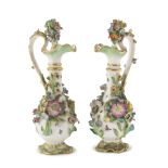 A PAIR OF SMALL PORCELAIN CRUETS, 19TH CENTURY in white and polychrome enamel with embossed floral