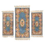 PARURE OF TIEN-TSIN CARPETS, CHINA 20TH CENTURY with floral motifs on light blue ground. Measures