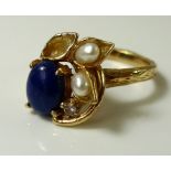 A 14ct gold ring of organic design, set with an oval lapis lazuli cabochon,