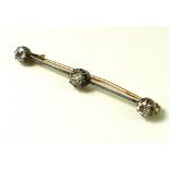 A three stone diamond bar brooch, the central diamond of approximately 0.6ct, 5.5 by 5.4 by 3.