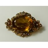 A Victorian 9ct gold brooch set with large oval cut citrine and surrounded by seed pearls,