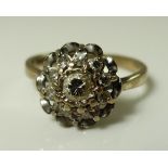 An 18ct white gold and diamond cluster ring, the central diamond of approximately 0.1ct, 3.