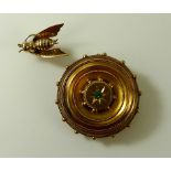 A 19th century gold circular brooch, set to the centre with an emerald in a sunburst setting,