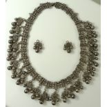 A 19th century Indian Mughal silver necklace of bells suspended from quatrefoil shaped drops with