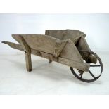 An early 20th century wooden garden wheelbarrow, 71 by 170 by 58cm high.